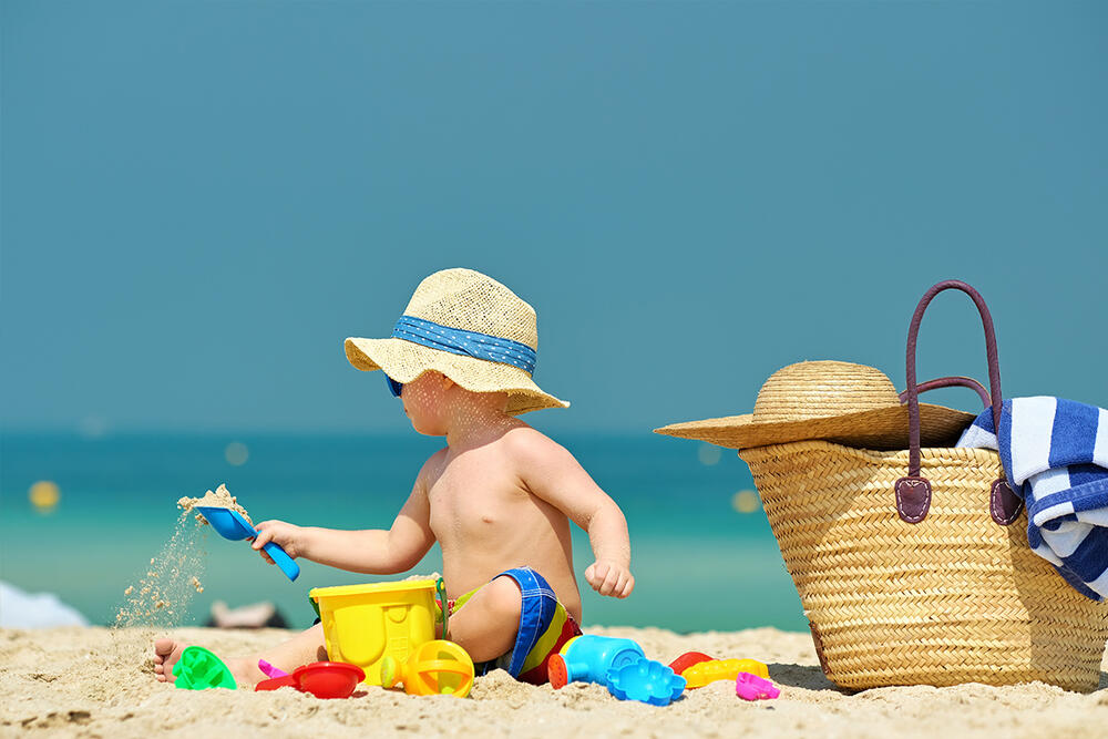 more, letovanje, dete, beba, beba na plaži, dete na plaži, igranje u pesku, zaštita od sunca, leto, kofica, lopatica, igračke za plažu